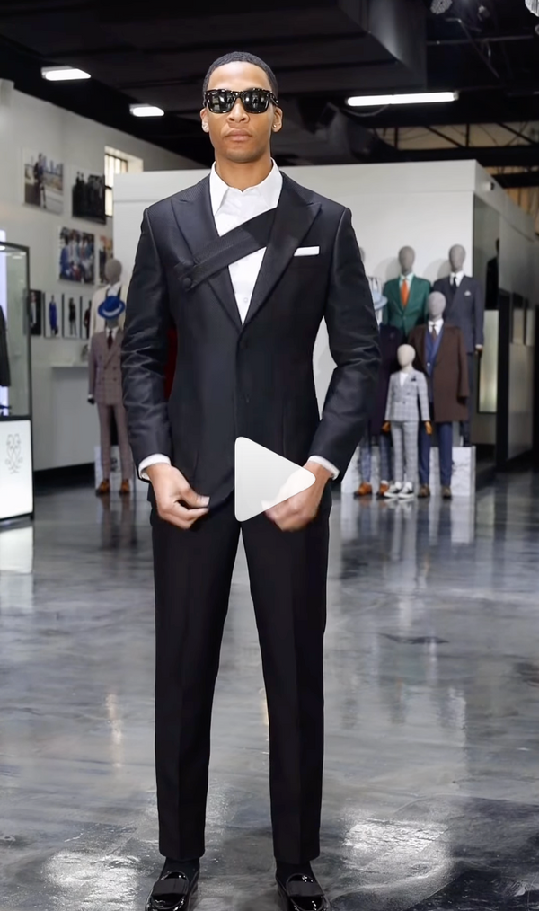 Black tuxedo with white boutonniere styled in a room with mannequins