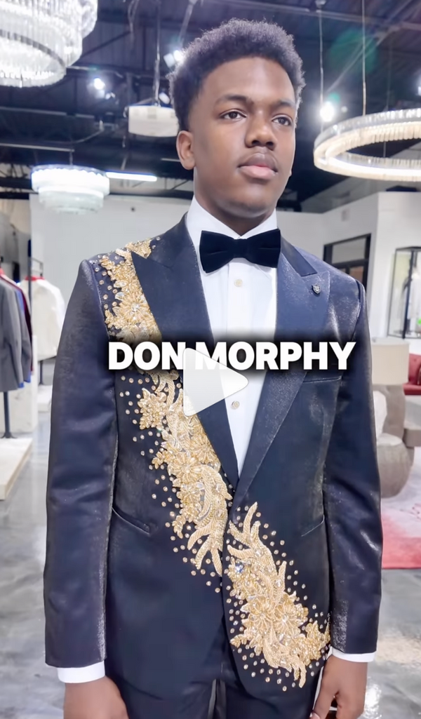 Young man in black suit with gold embroidery, bow tie in elegant setting