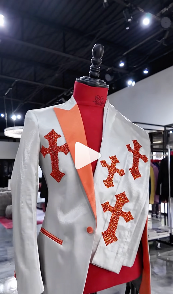 Mannequin in white suit with orange accents in a modern showroom setting