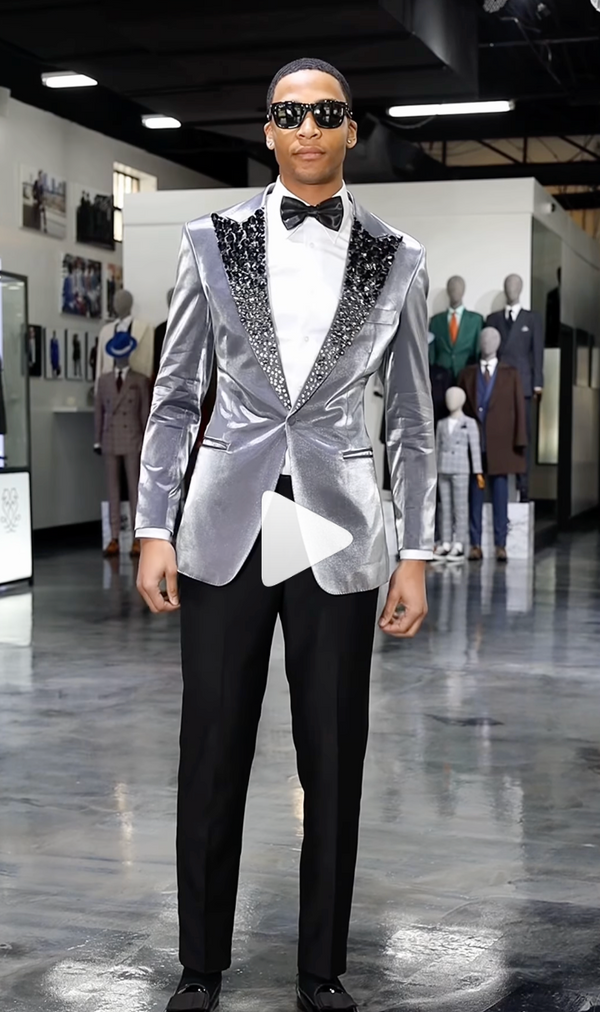 Person in silver tuxedo with black lapels and sunglasses in showroom