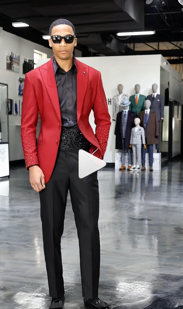 Man in red embellished jacket and sunglasses posing in a stylish boutique