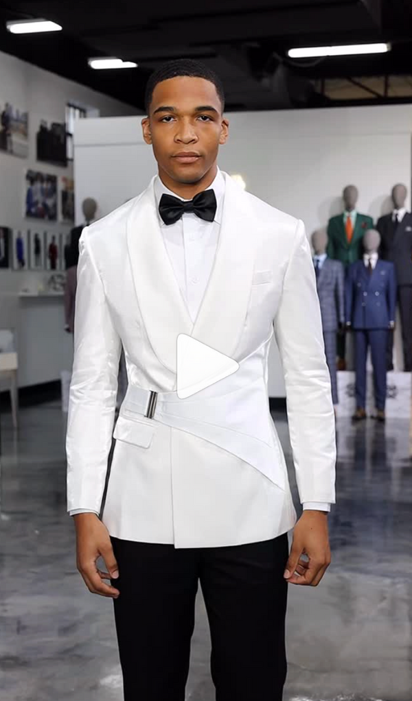 Man in white tuxedo and bow tie posing indoors with mannequins behind