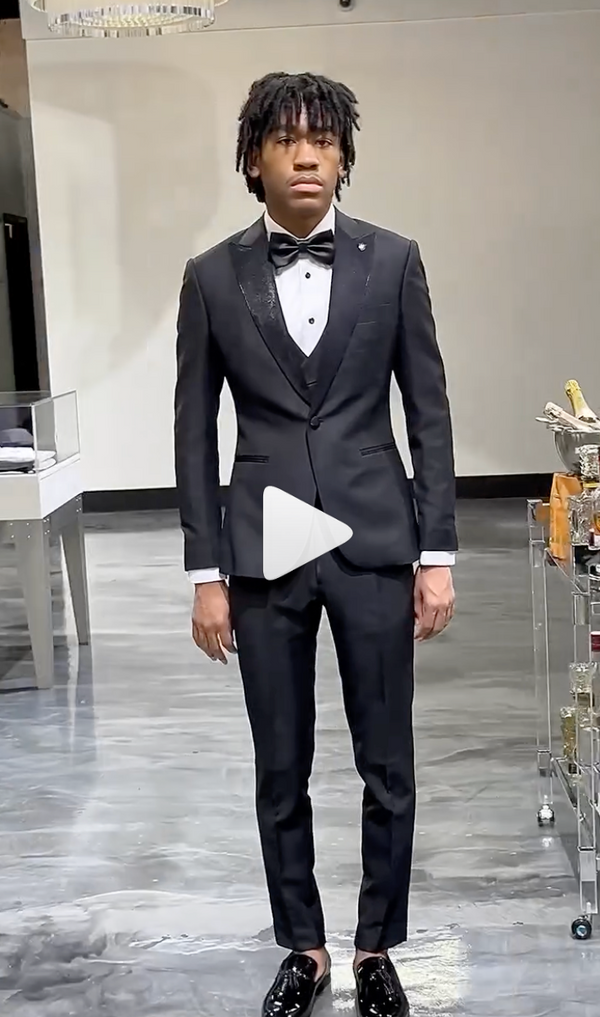 Man in black tux with polished shoes in elegant modern space
